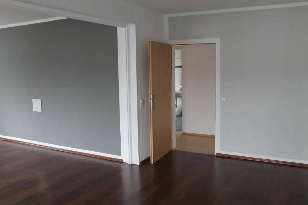 Wohnbereich mit breitem Durchgang und Blick in den Flur