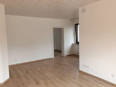 Wohn- und Essbereich mit Laminatboden und Tür zum Flur