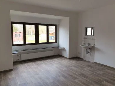 Zimmer mit breiter Fensterfront zum Garten